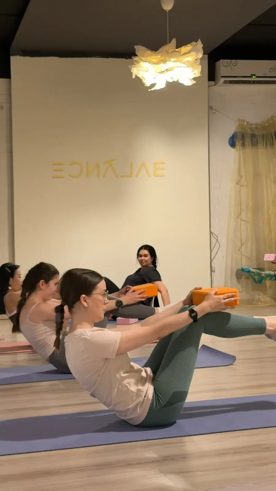 Balance studiyasida gilamchalarda pilates bilan shugʻullanayotgan ayollar, Toshkent